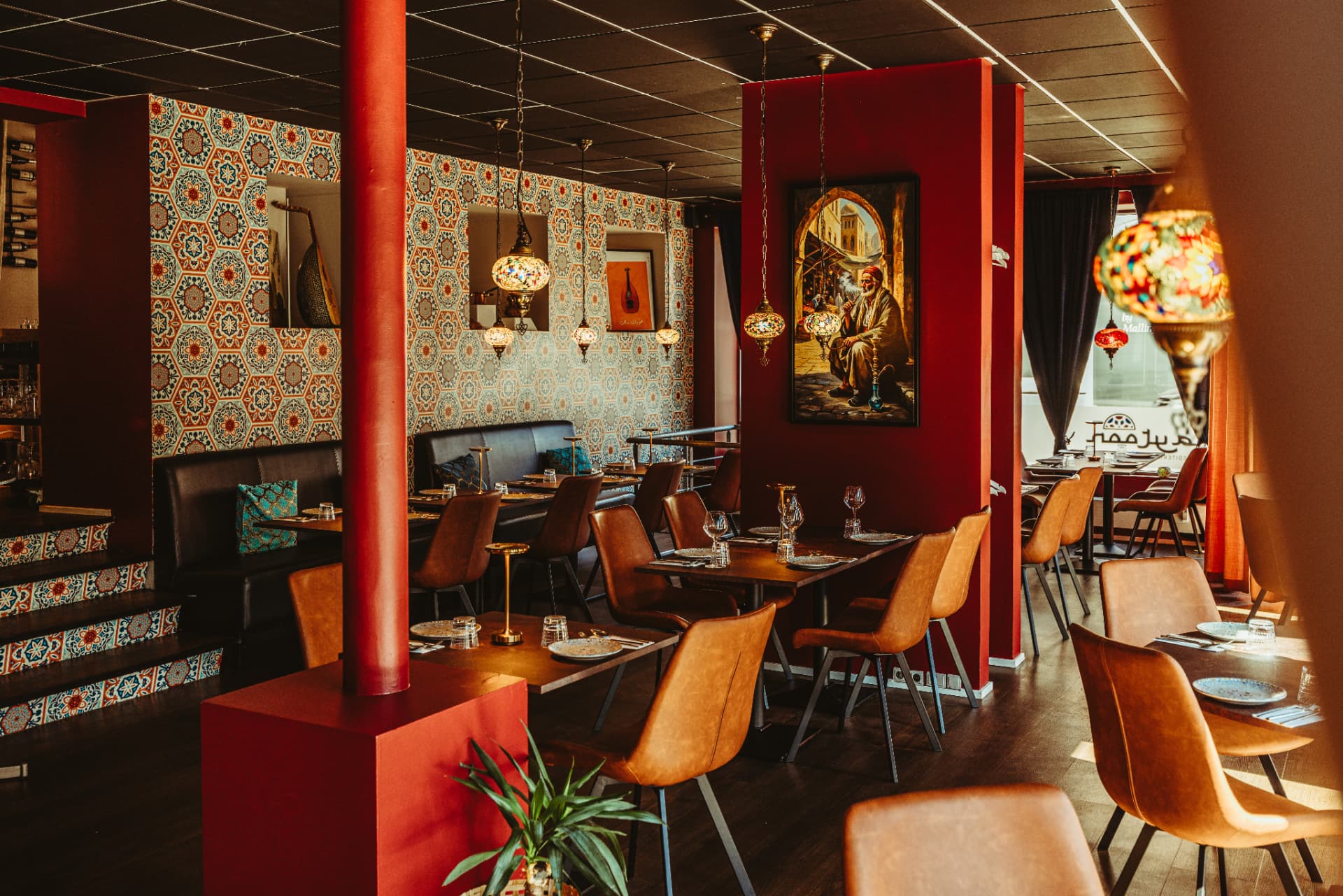 Restaurantlokale hos Zaytoon med mosaiklamper og dækkede borde